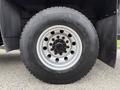 Close-up of a black tire mounted on a silver wheel featuring multiple bolt holes and the tread pattern labeled Hercules 22.5 80 R22.5