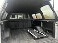 Interior of a 2014 Ford F-150 truck bed with a black-lined surface and a rolling toolbox frame positioned inside