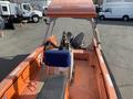 A 2007 Fassmer 20 Foot Fast Rescue Boat featuring a bright orange interior with a central steering console and a mounted outboard motor