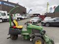 A 2009 John Deere 2653B Precision golf course mower in green and yellow with a seat for the operator and multiple attachments for grass cutting
