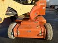 A 2012 JLG E400AJFN aerial lift machine with large rubber tires and an orange body featuring various control panels and safety labels