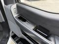 Interior door panel of a 2021 Ford F-150 featuring window controls and a textured surface design