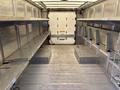 Interior of a 2012 Ford Econoline with metal shelves on both sides and open space along the floor