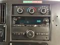 Dashboard of a 2020 Chevrolet Express featuring climate control knobs and a radio with buttons for tuning and media selection