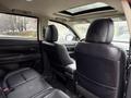 Interior view of a 2016 Mitsubishi Outlander showing black leather seats and a sunroof with visible headrests and armrest in the rear passenger area