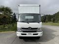 A white 2018 Hino 195 box truck facing forward with a flat front and large windshield and a logo on the front grille