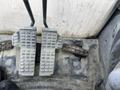 Foot pedals of a 2018 John Deere 350 showing two metal pedals with textured surfaces for traction and a lever on the side
