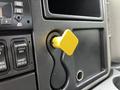 A yellow square knob on the dashboard of a 2011 International 4400 truck with various control buttons nearby