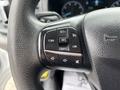 Close-up of the steering wheel controls of a 2020 Ford Transit 250 featuring buttons for cruise control audio settings and phone functions