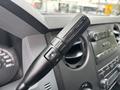 Close-up of the gear shift lever in a 2013 Ford F-250 SD with buttons for adjusting settings and a textured grip