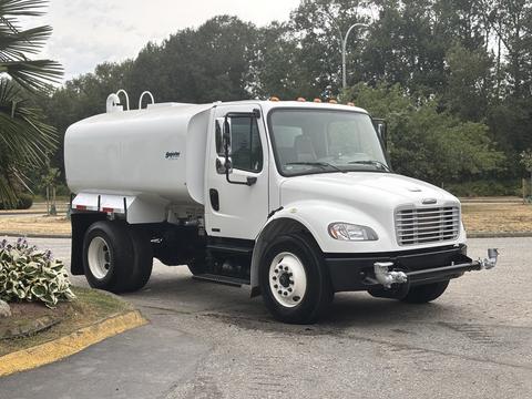 A 2006 Freightliner M2 106 fuel truck with a white tank and visible side mirrors parked on a street