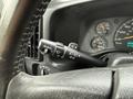 Close-up of the steering wheel and control stalks of a 2004 Chevrolet Express showing turn signal and wiper controls