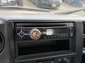 A car stereo display with a digital interface showing the time and Bluetooth connectivity features in a vehicle dashboard