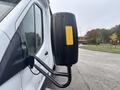 Close-up of a 2021 Ford Transit-350 side mirror featuring a round blind spot indicator with a reflective yellow section