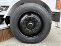 A close-up of a black Michelin tire mounted on a steel wheel with a central hub and multiple lug nut holes visible