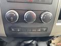 Control panel of a 2011 Dodge Ram 5500 featuring climate control knobs and auxiliary buttons