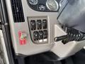 Interior view of a 2015 Peterbilt 337 showcasing the dashboard with various control knobs and switches along with a key ignition system