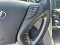 Close-up of a steering wheel in a 2015 Hyundai Sonata featuring control buttons for cruise settings and audio functions