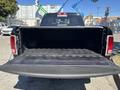 A 2015 RAM 1500 truck with its tailgate open revealing an empty truck bed