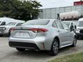 A silver 2025 Toyota Corolla with a sleek design, featuring a modern rear end and distinct taillights