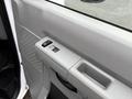 Close-up of the interior door panel of a 2019 Ford Econoline featuring power window controls and a door handle