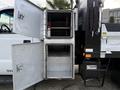 A 2015 Ford F-350 with an open metallic storage box featuring two compartments one with shelves and a fire extinguisher visible inside
