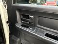 The interior door handle and control panel of a 2013 RAM 3500 featuring a textured black surface and window controls