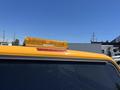 A yellow 2013 Chevrolet Silverado 1500 with a roof-mounted amber emergency light on top of the cab