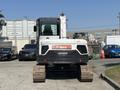 A 2010 Bobcat E80 excavator with a white and black body and tracked undercarriage facing forward