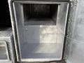 A metallic storage compartment of a 2015 Ford F-350 with a smooth interior and no visible contents