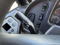 Close-up of the control lever and dashboard interface of a 2011 Freightliner B2 featuring various buttons and gauges for vehicle operation