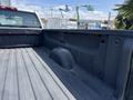 View of the bed of a 2016 Chevrolet Silverado 2500HD showing a textured black surface with a wheel well and no cargo inside