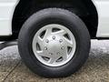 Close-up of a silver alloy wheel with a tire labeled DynaPro AS on a 2013 Ford E-350
