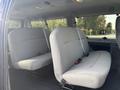 Interior of a 2013 Ford E-350 Super Duty showing gray fabric bench seats arranged in a row with seat belts attached