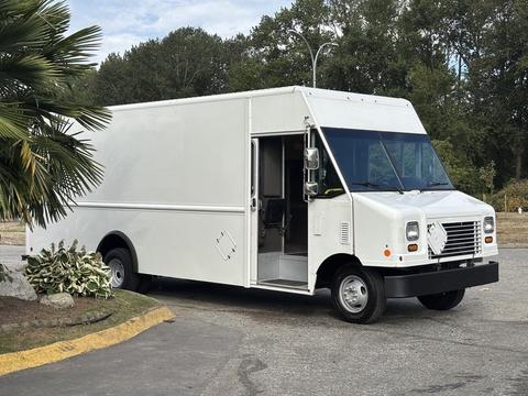 A white 2018 Ford Econoline cargo van with one door open showcasing the driver's seat and interior details