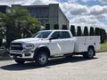 A white 2021 RAM 5500 pickup truck with a utility bed and tool compartments on the sides