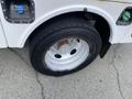 A close-up of a 2015 Ford F-550's front wheel and tire showcasing a silver alloy rim and a black tire with visible tread detail