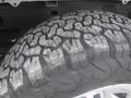 Close-up of a worn tire with a deep tread pattern mounted on a wheel, part of a 2015 Chevrolet Silverado 1500