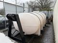 A large white tank mounted on a black hook-lift frame designed for de-icing purposes with a capacity of 1250 gallons