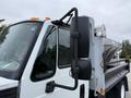 A 2012 International TerraStar truck with a prominent side mirror and a flatbed equipped with a metal container attached to the rear