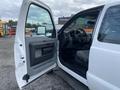A 2015 Ford F-250 Super Duty with an open driver's door revealing the interior and dashboard