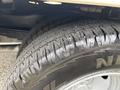Close-up of a tire on a 2014 Ford E-350 featuring thick treads and a metallic rim with spokes