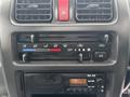 Dashboard controls of a 2010 Suzuki Carry featuring climate control knobs and a radio display