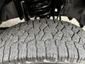 Close-up of a rugged tire tread of a 2013 Ford F-250 SD showcasing deep grooves and a sturdy design