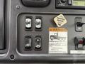 Dashboard controls of a 2005 Freightliner M2 106 including parking brake switch warning label and toggle switches for mirror heat and other functions