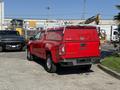 A red 2018 GMC Canyon pickup truck with a toolbox cover on the bed parked on a concrete surface