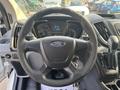 A 2016 Ford Transit 150 steering wheel with a Ford emblem and dashboard display showing various gauges and information