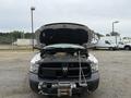 A 2016 RAM 1500 with its hood raised revealing the engine compartment and parts inside