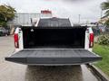 A 2018 Ford F-150 with the tailgate down showing an empty truck bed and black liner