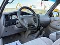 Interior view of a 2004 Toyota Tacoma showing the dashboard steering wheel gear shift and seats in light gray fabric